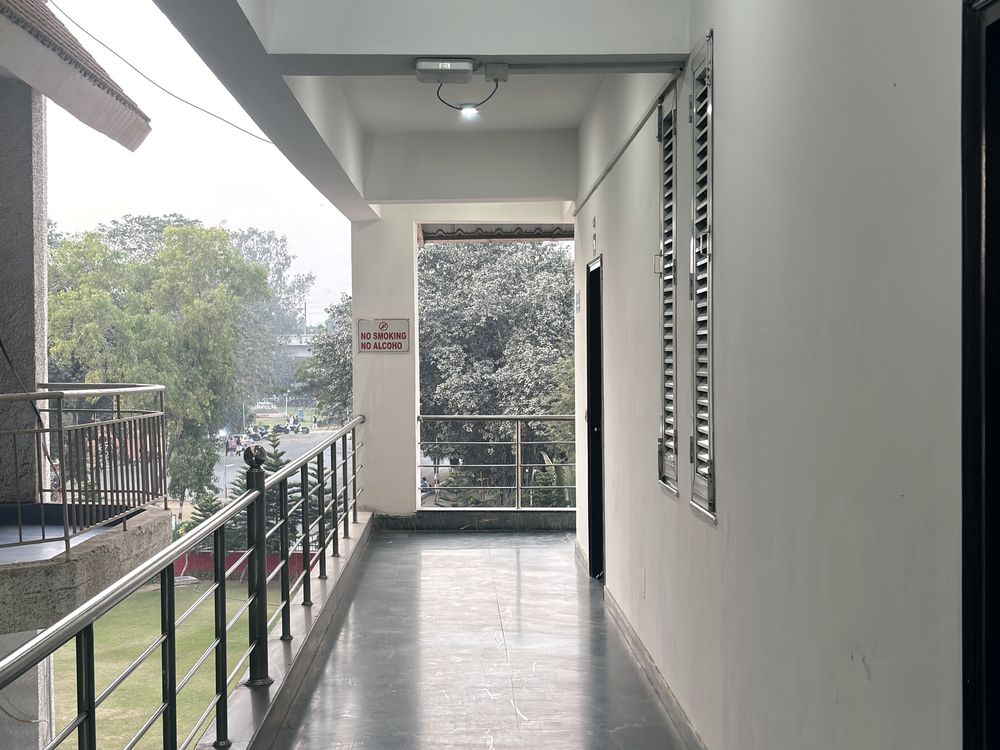 A quiet institute corridor in daylight, doors along one side.