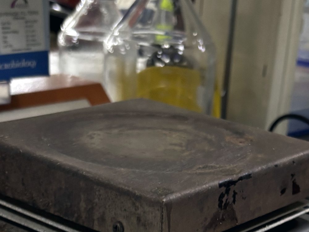 The scorched top plate of a hot plate, its finish worn through from years of use.